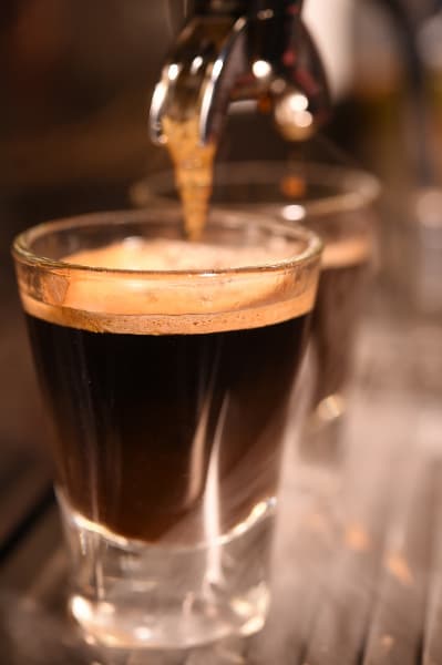 A cup of cold brew coffee being poured from a draft system
