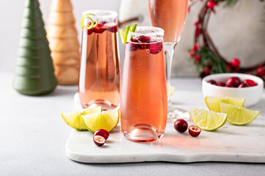Festive mimosa cocktail with cranberry juice and lime zest