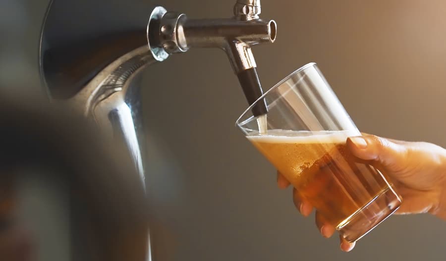 Pouring craft beer into glass from keg