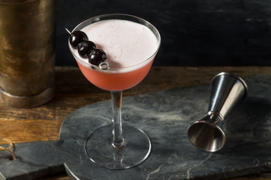 Pink lady cocktail with cherries as a garnish