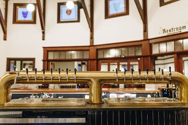 Beer taps placed underneath wooden bar in establishment