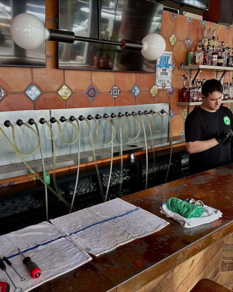 Northwest Draft Technicians team member cleaning beer lines inside bar